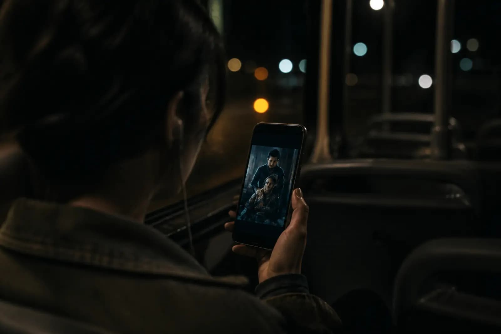 Someone watching a vertical short drama on a phone at night